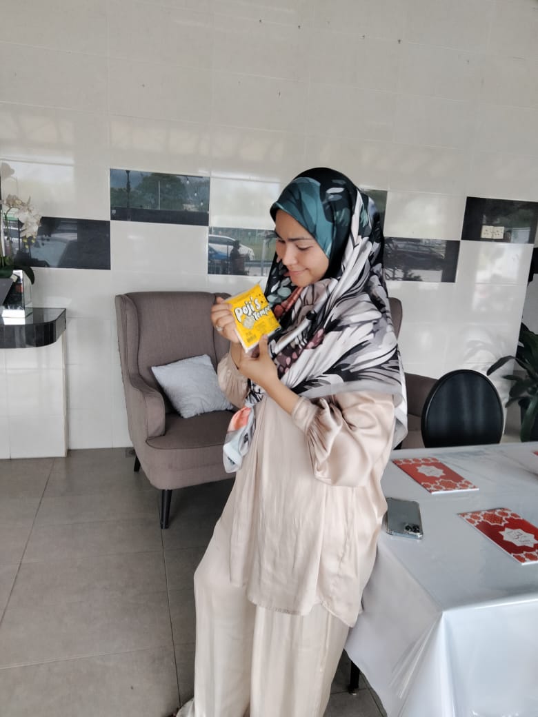 Seorang pelanggan wanita melihat pek Pojie’s Tempe yang dipegangnya