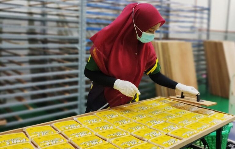 Pekerja Pojie’s memeriksa bungkusan tempe di kilang
